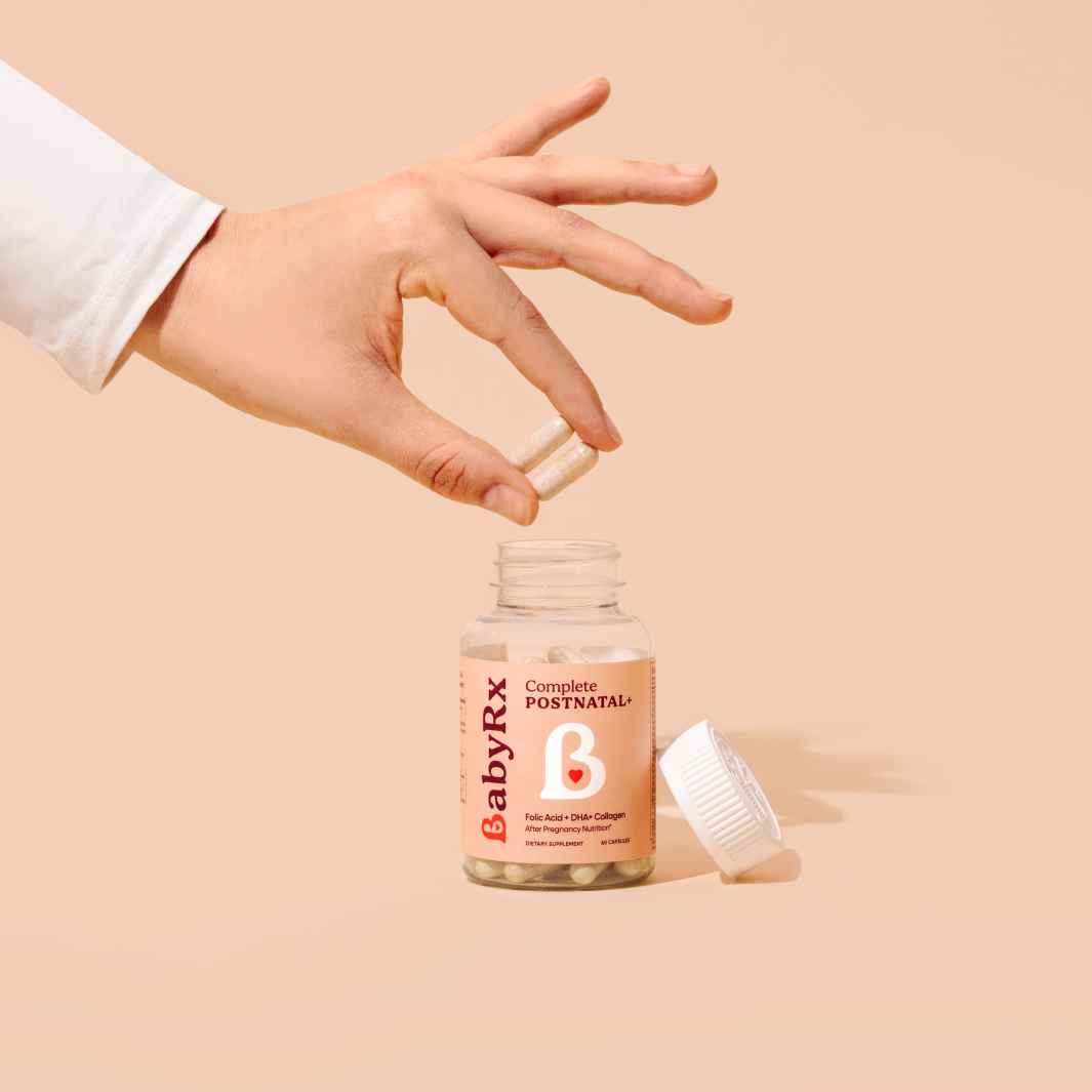 Hand holding BabyRx Postnatal capsules