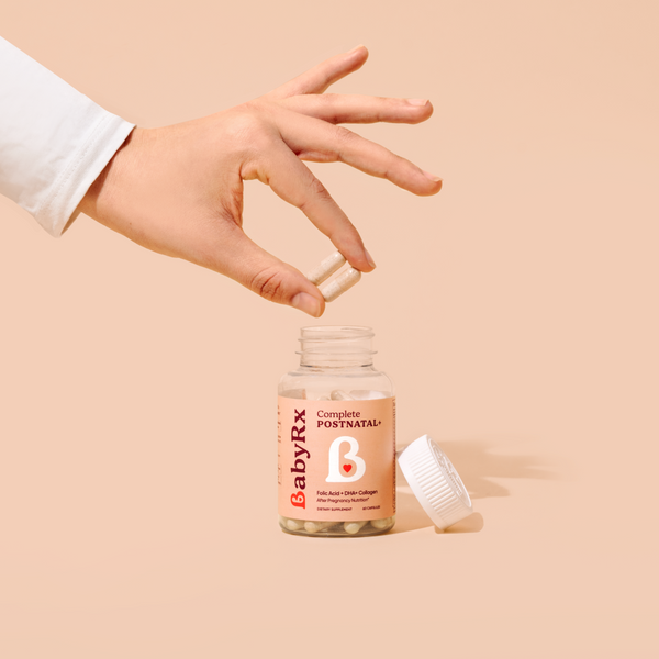 Hand holding BabyRx Postnatal capsules